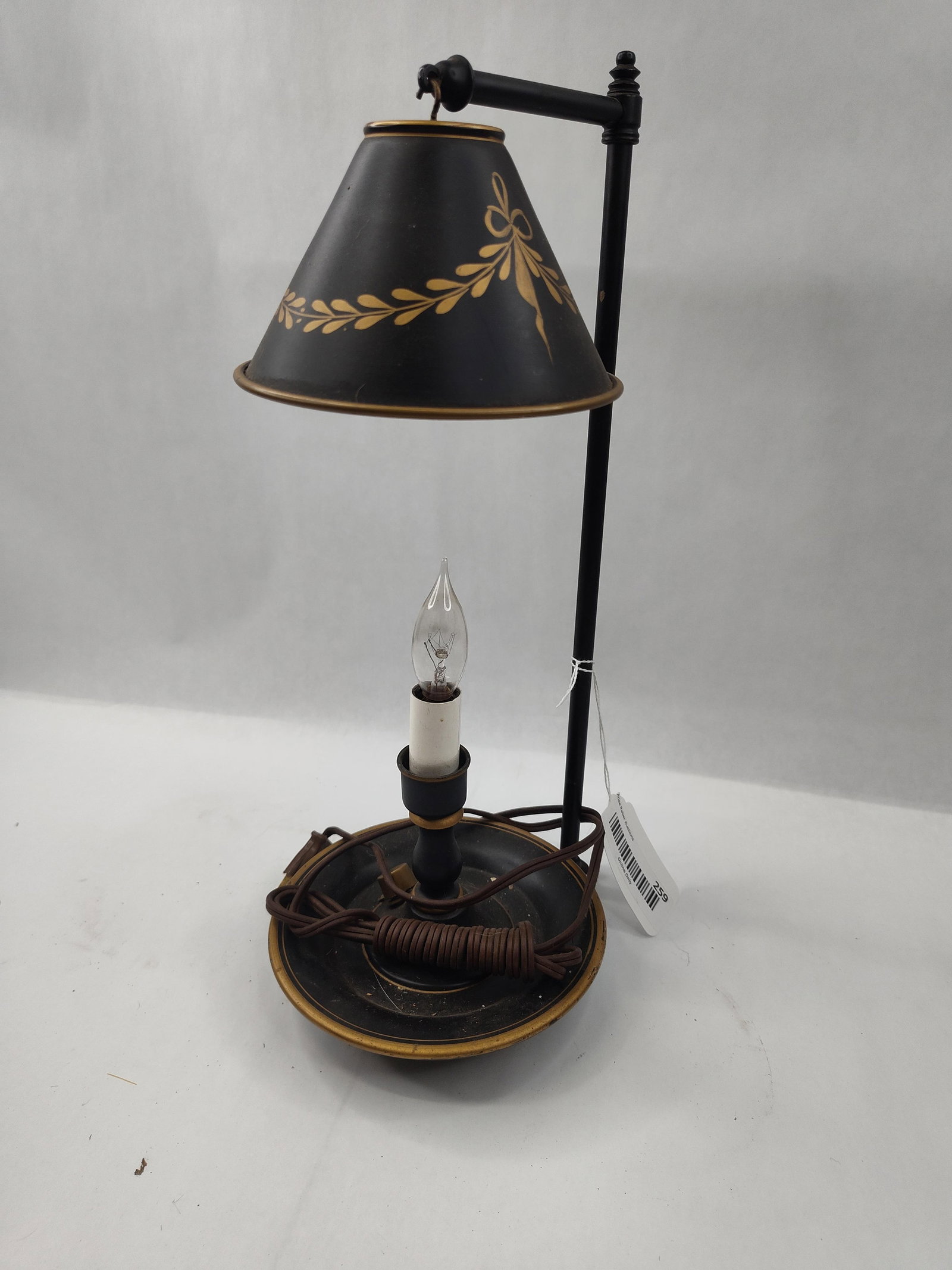 Toleware Style Table Lamp w/ Adj Shade: A black and gold painted metal table lamp featuring toleware styling. The lamp is constructed with a circular tray base supporting a central pedestal for a single candelabra-style bulb socket,