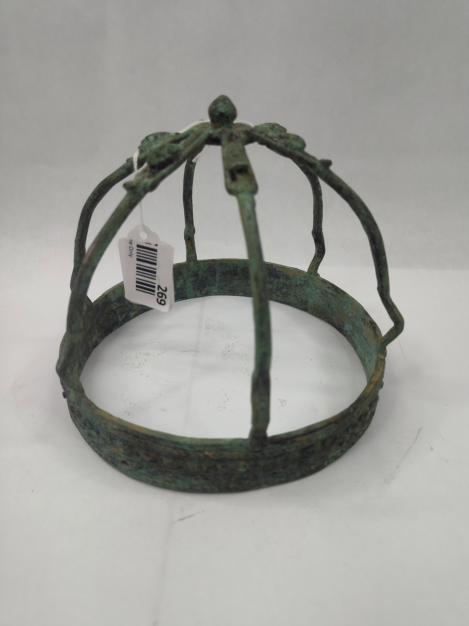 Bronze Openwork Votive Crown: A bronze-colored metal crown of openwork dome construction, featuring a wide circular headband base. The headband is decorated with a cast repeating register consisting of two rows of small circular b