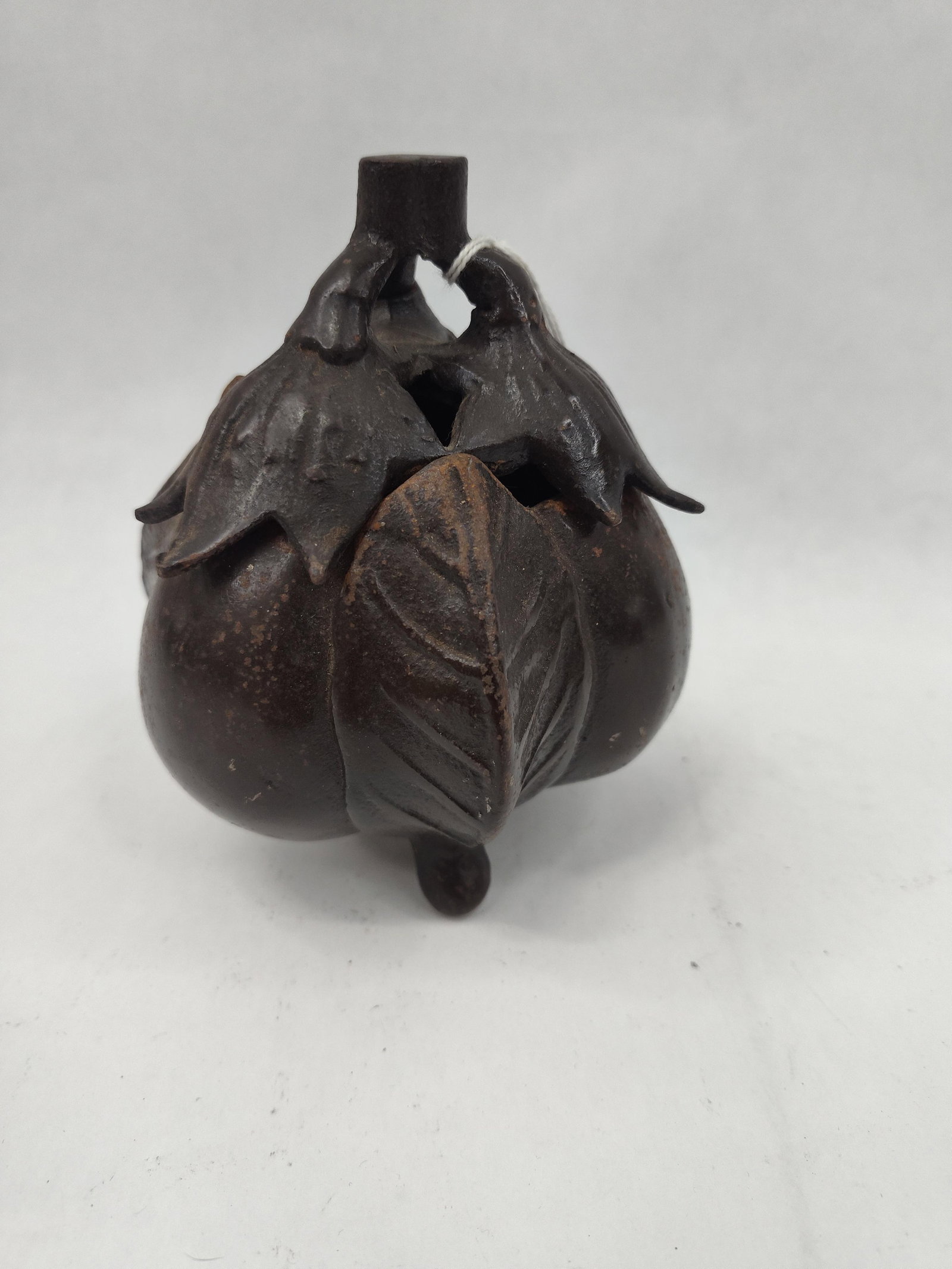 Japanese Cast Iron Eggplant Koro: A Japanese tripod koro or incense burner cast in the form of three joined eggplants (nasu). The vessel is constructed from dark-patinated cast iron. The body is comprised of three rounded lobes