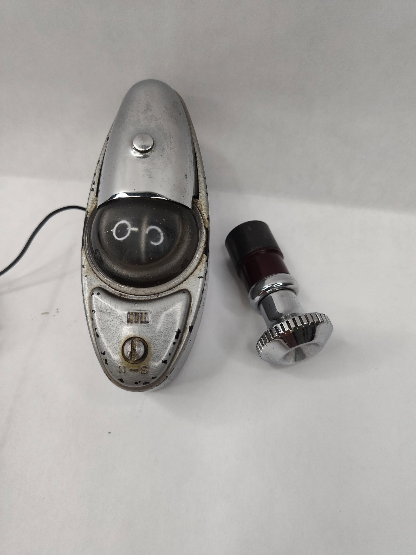 Hull Beaconlite Compass & Lighter: This lot consists of two automotive accessories: a Hull Beaconlite illuminated compass and a separate cigarette lighter plug. The compass is housed in a streamlined, chrome-plated metal casing with a