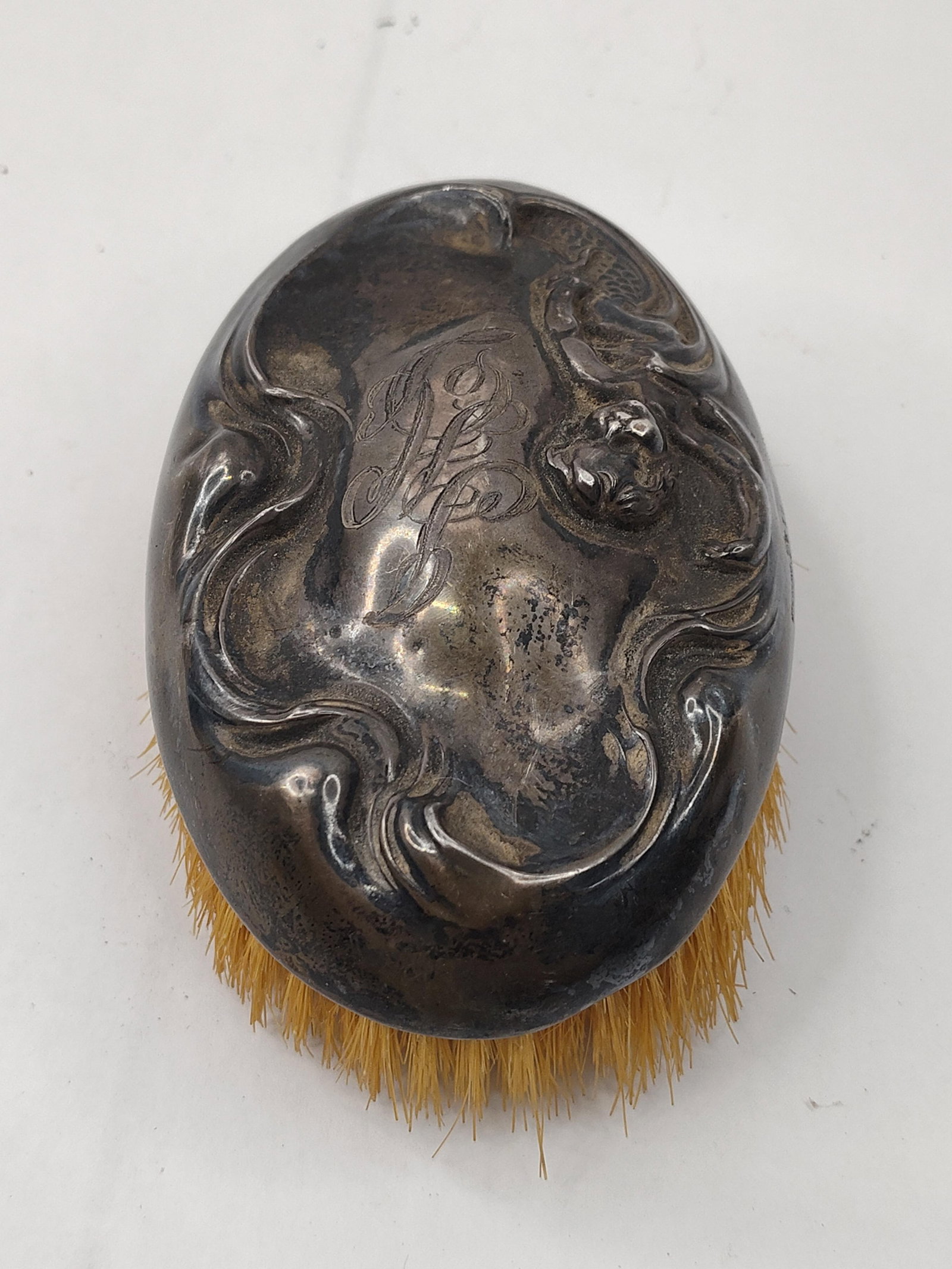 Art Nouveau Str. Mermaid Clothes Brush: This Art Nouveau sterling silver clothes brush features an oval cap decorated in high-relief repousse. The ornamentation depicts a mermaid figure with a scaled tail amidst stylized, flowing wave or