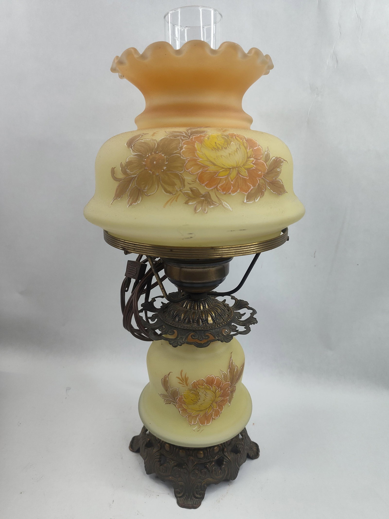 Frosted Satin Glass Hurricane Lamp: A mid-20th century electric hurricane-style parlor lamp featuring a two-part glass body with a frosted, pale yellow satin finish. The upper shade is designed with a ruffled, crimped top rim featuring