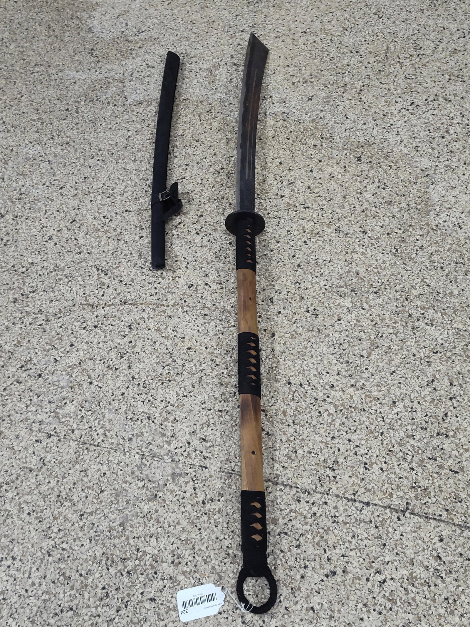 Nagimaki Style Polearm Edged Weapon: This contemporary polearm-style edged weapon is designed in the manner of a Japanese nagamaki. The weapon features a curved, single-edged steel blade with two longitudinal fullers running along the