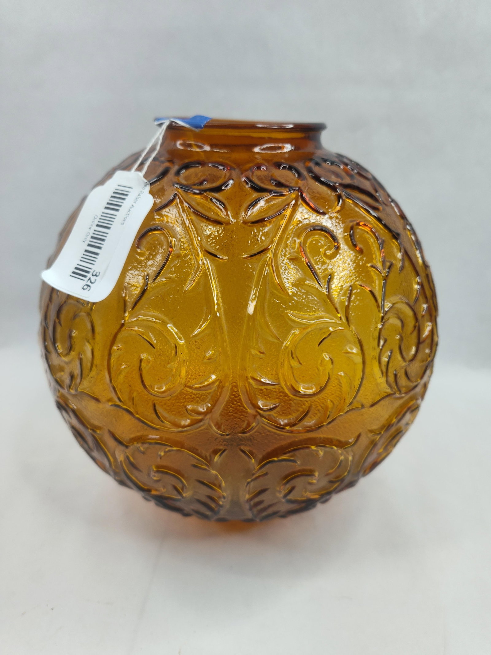Amber Glass Scroll Rose Bowl: A amber glass rose bowl or vase of globular form, crafted using a pressed glass technique as evidenced by a vertical mold seam visible on the side. The vessel features a textured exterior with an