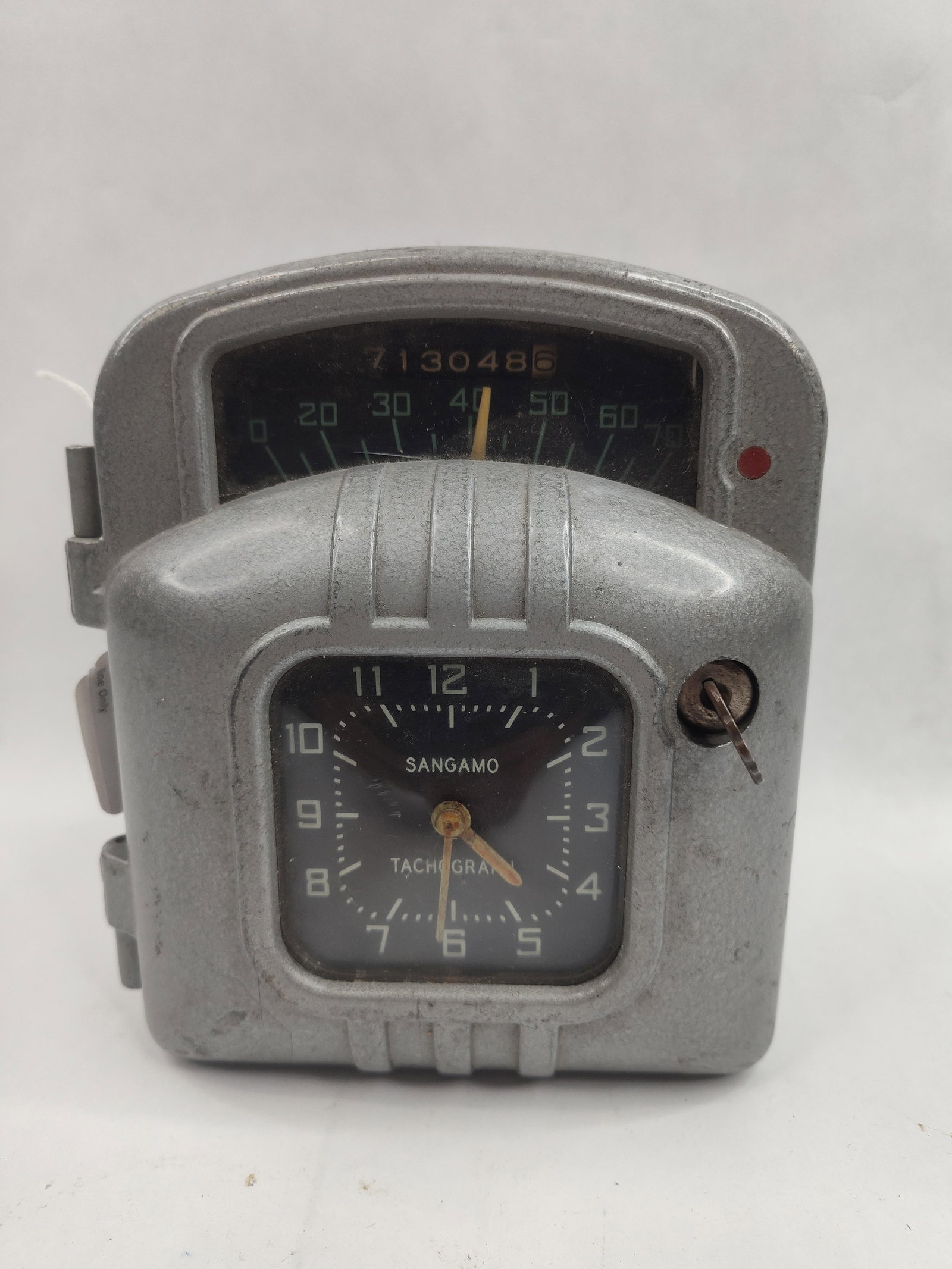 Sangamo Model AA Tachograph & Clock: A mid-century American electromechanical vehicle monitoring device, identified as a Sangamo Tachograph. The unit is constructed from a heavy cast metal housing with a hammer-tone gray finish. The