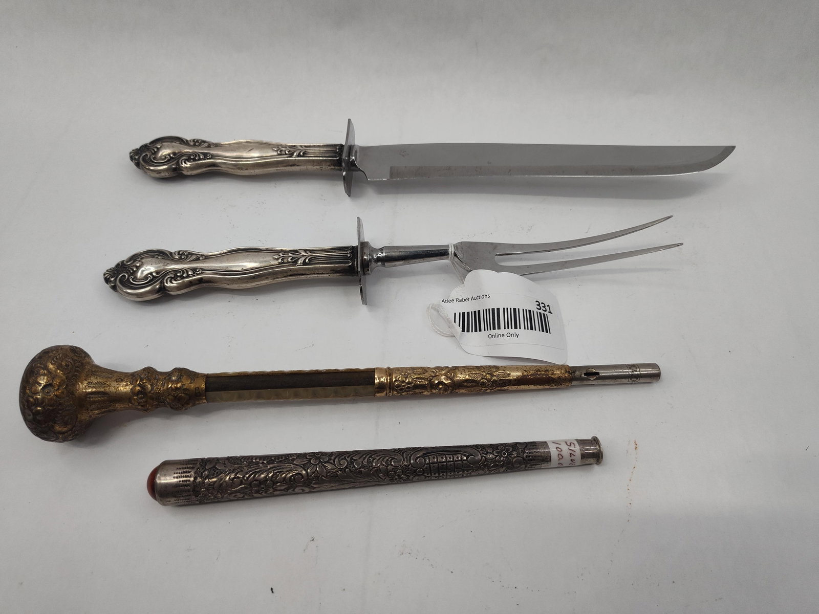 Set Str. & Mixed Metal Tableware: This collection includes a variety of silver and mixed-metal items featuring ornate decorative work. A roast carving set includes a knife and a two-tine fork with handles in a scrolling foliate