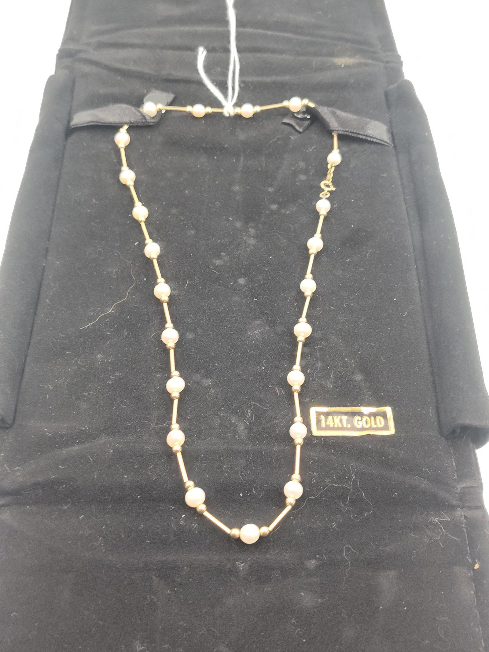Mexican 14K Gold & Pearl Necklace: A Mexican 14 karat yellow gold station necklace featuring twenty spherical white cultured pearls, each measuring approximately 3-4mm. The pearls alternate with polished gold tube spacers and small