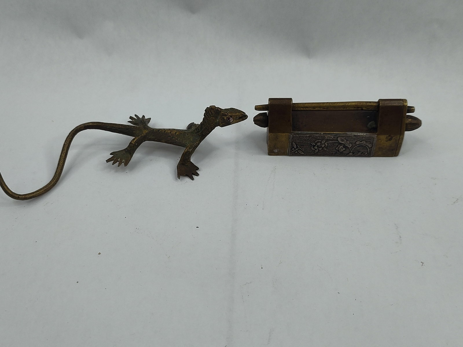 Brass Padlock w/ Floral Plaque & Key: This set comprises a rectangular brass-cased pad-style lock and a coordinating figural key. The lock body is constructed of cast brass with a horizontal slide shackle. The front face of the lock