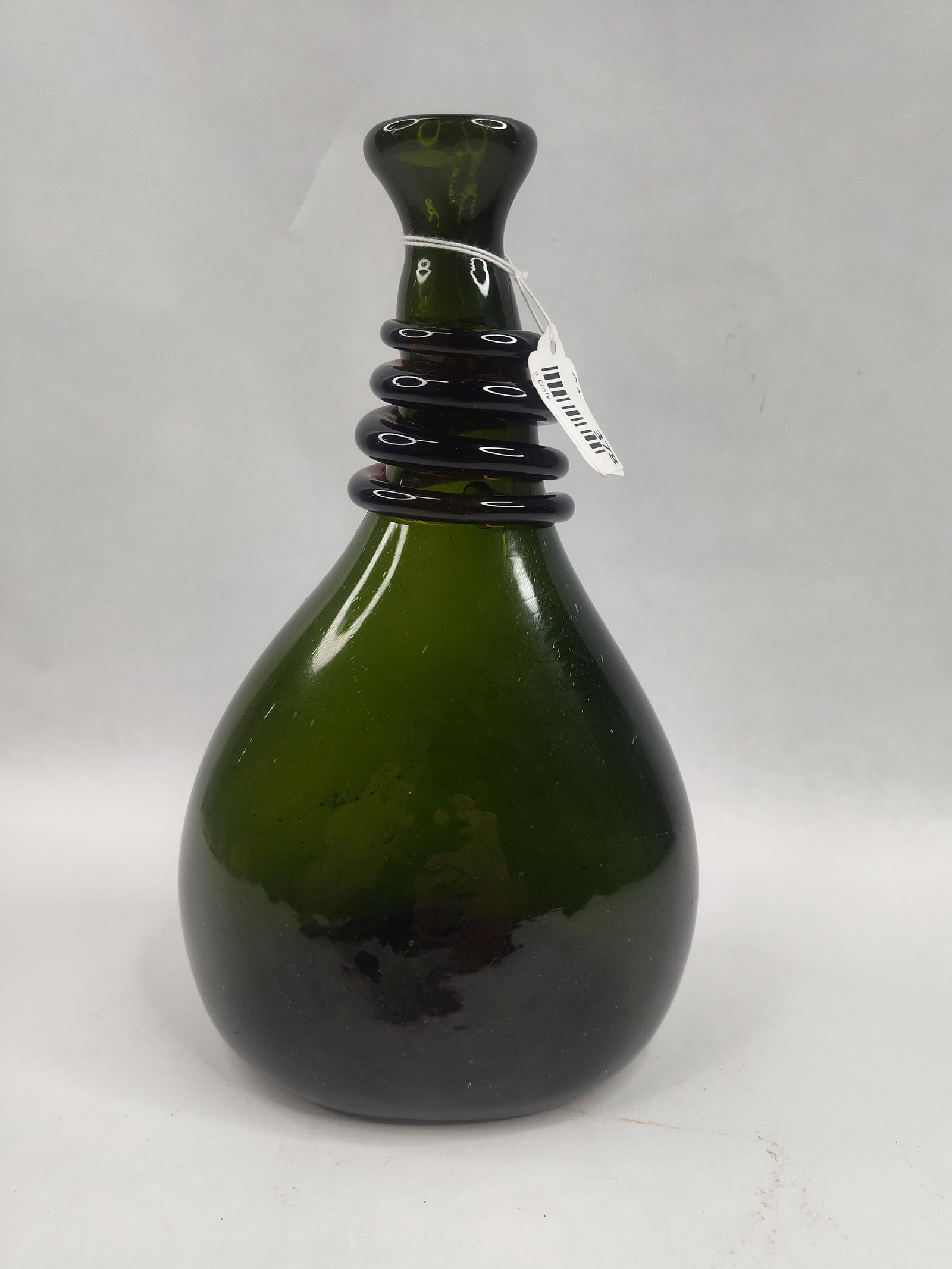 Green Glass Flask w/ Spiral Neck Trail: A hand-blown forest green glass flask or bottle featuring a translucent quality and visible internal bubbling (seeds). The vessel is constructed with a bulbous, pear-shaped body that tapers into a sle