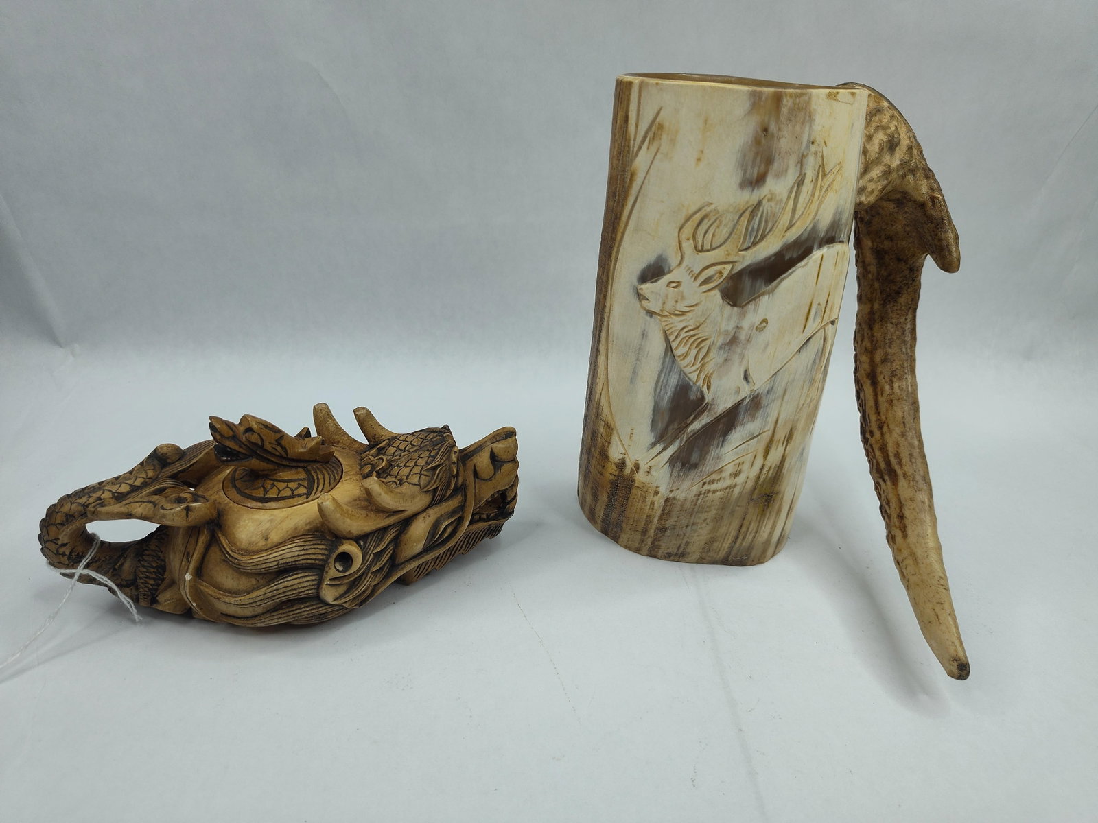 Pair Carved Horn & Antler Objects: A group of two hand-carved decorative items crafted from organic materials including horn and antler. The first object is a lidded vessel or teapot intricately carved in the form of a dragon. The