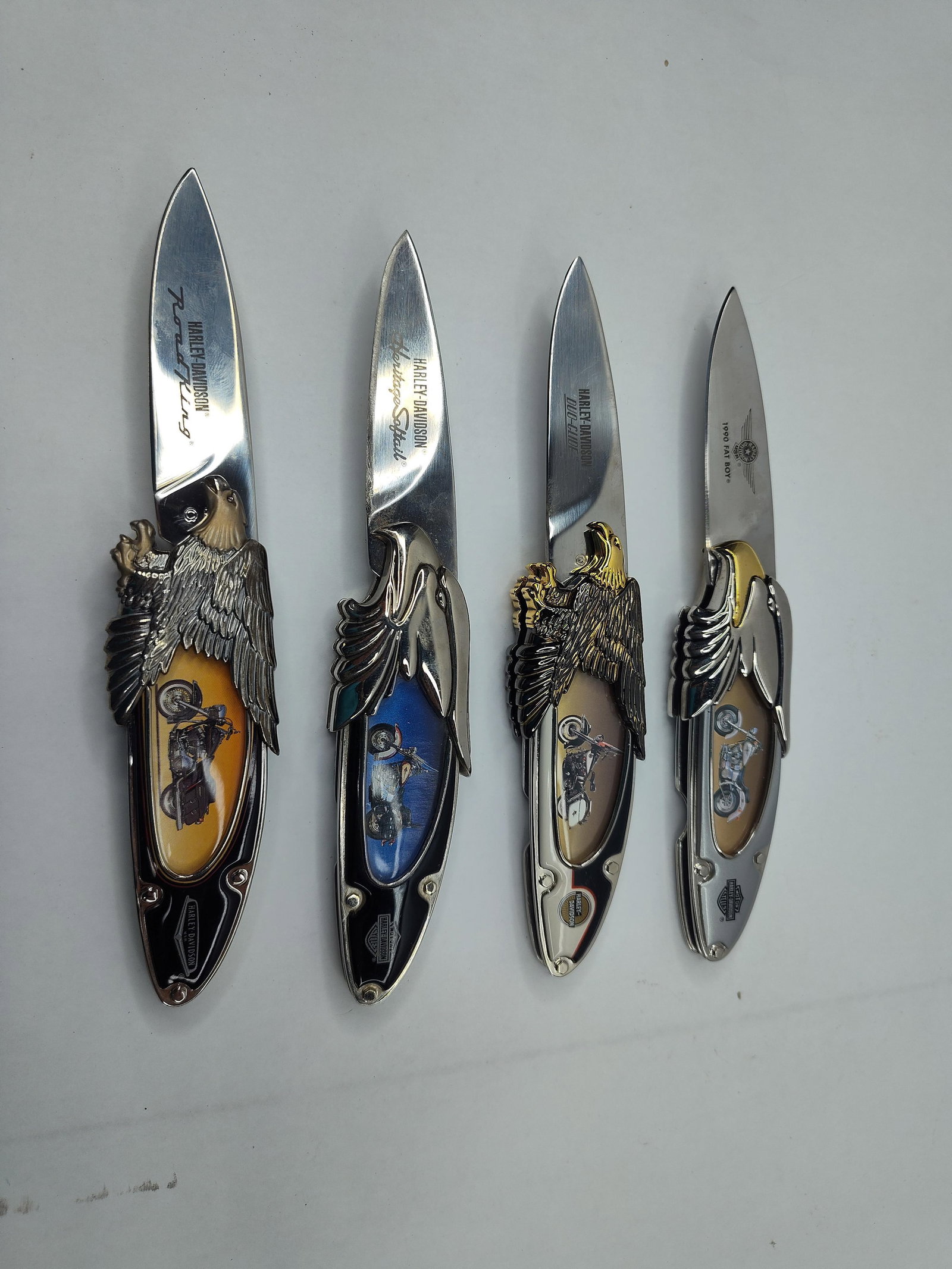 Franklin Mint Harley-Davidson Knives: A group of folding pocket knives produced for Harley-Davidson, featuring stainless steel drop-point blades and decorative cast metal handles. Each knife is themed after a specific motorcycle model,