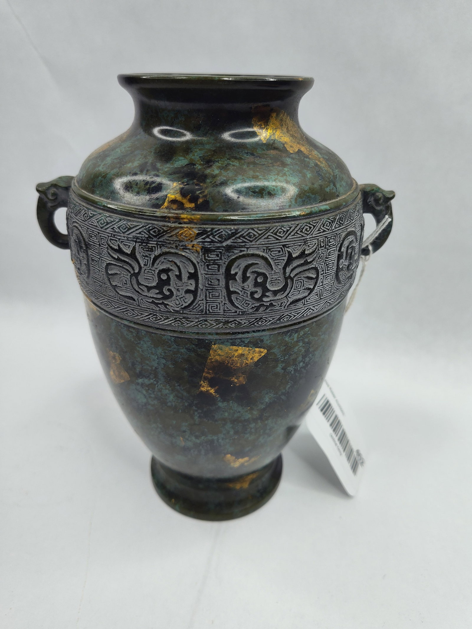 Archaic Style Gilt Splash Bronze Vase: A cast bronze baluster-form vase featuring a varied verdigris and dark brown patina. The vessel is characterized by a wide median band executed in low relief, depicting stylized archaic taotie or