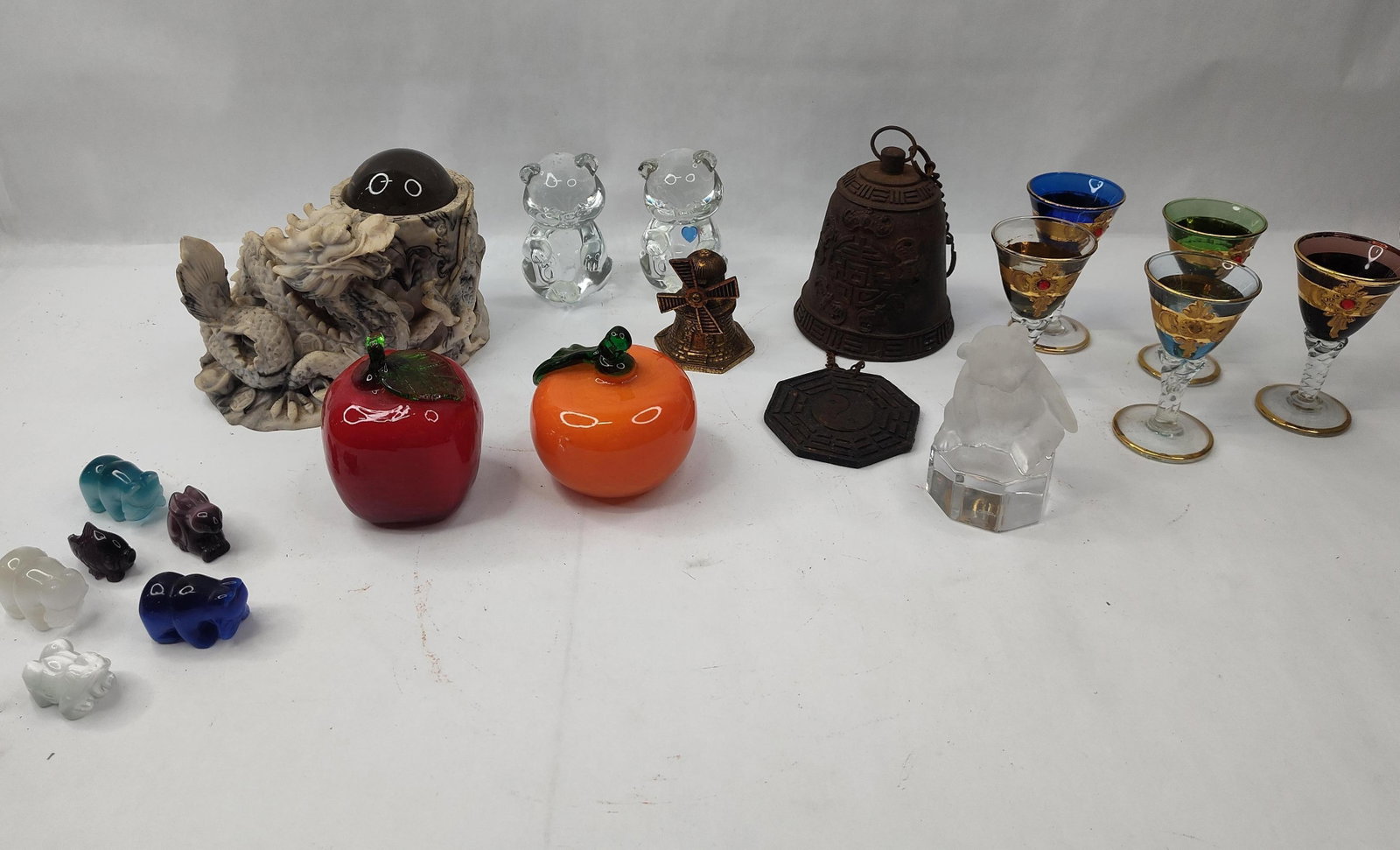 Asian & European Objects & Glassware: This lot comprises an assortment of decorative items and glassware in various materials. Included is a resin sculpture of a dragon with a scaled body and finned tail, coiled around a textured vessel