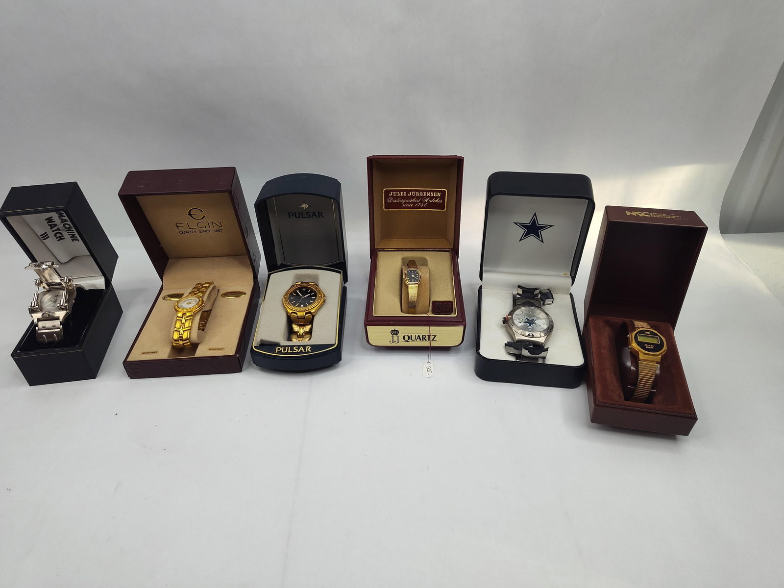 Set of & Modern Quartz Wristwatches: A collection of various quartz wristwatches in protective and original cases. The group features a silver-tone industrial-style wristwatch with a mechanical flip-top cover and spring-loaded pillars, t
