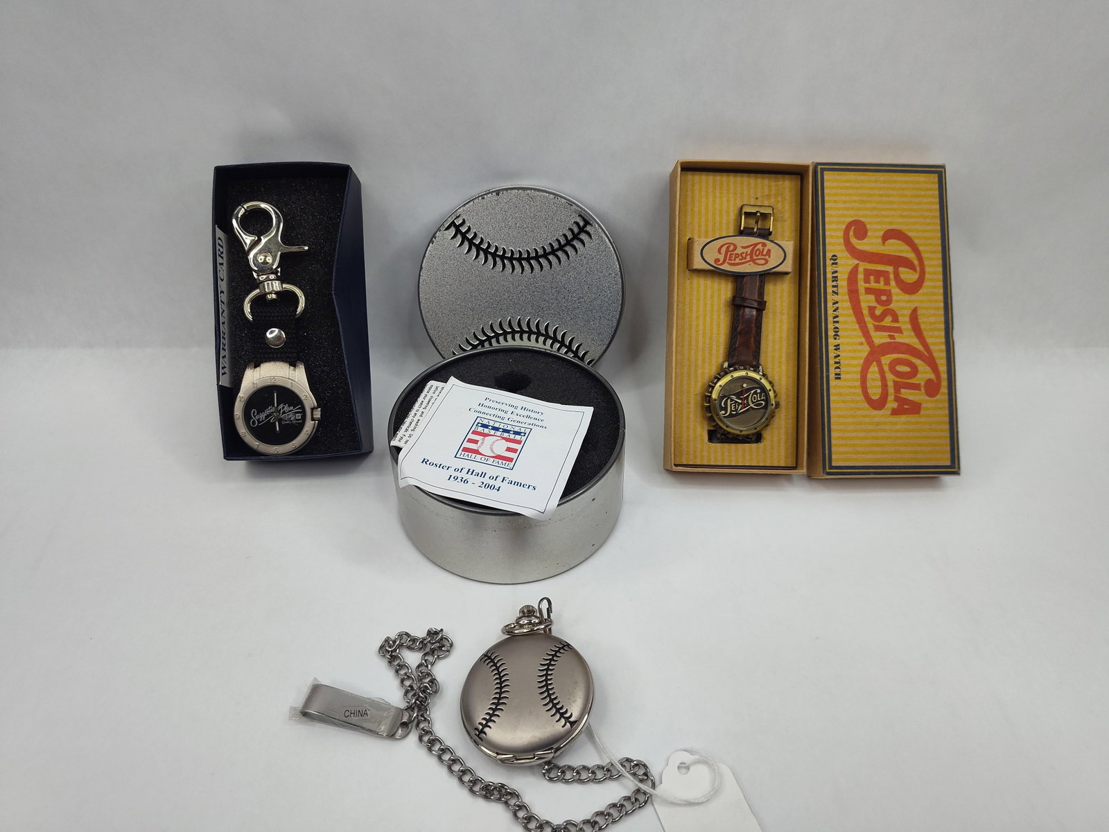 Pepsi & GM Novelty Watches, Set: This assortment includes several novelty horological items featuring American commercial and commemorative themes. One piece is a Pepsi-Cola quartz analog watch featuring a dial and bezel designed to 