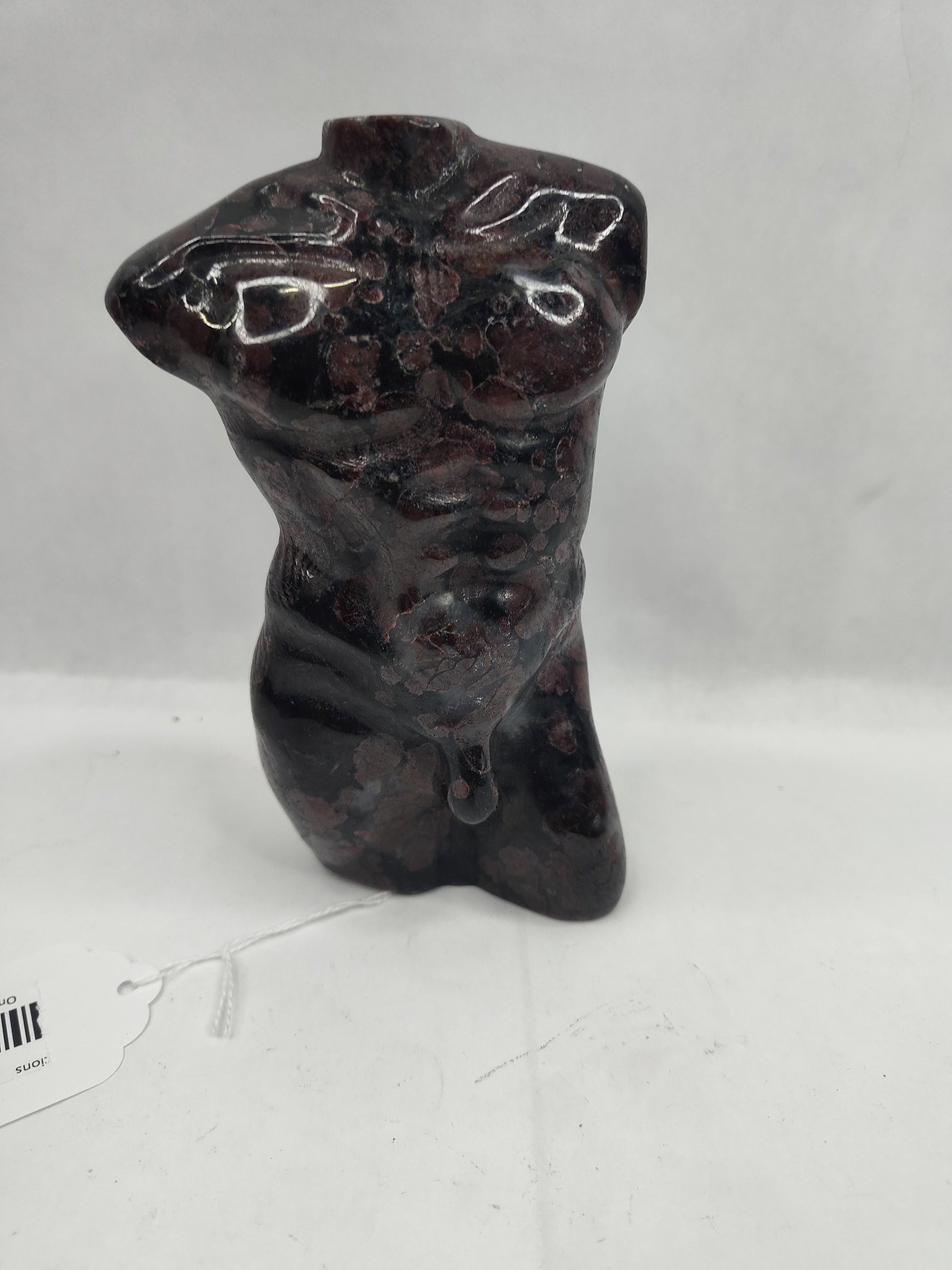 Garnet & Astrophyllite Male Torso: A hand-carved stone sculpture of a male torso, depicted with stylized muscular definition. The piece is fashioned from an igneous stone matrix, appearing as a dark, mahogany-to-black ground