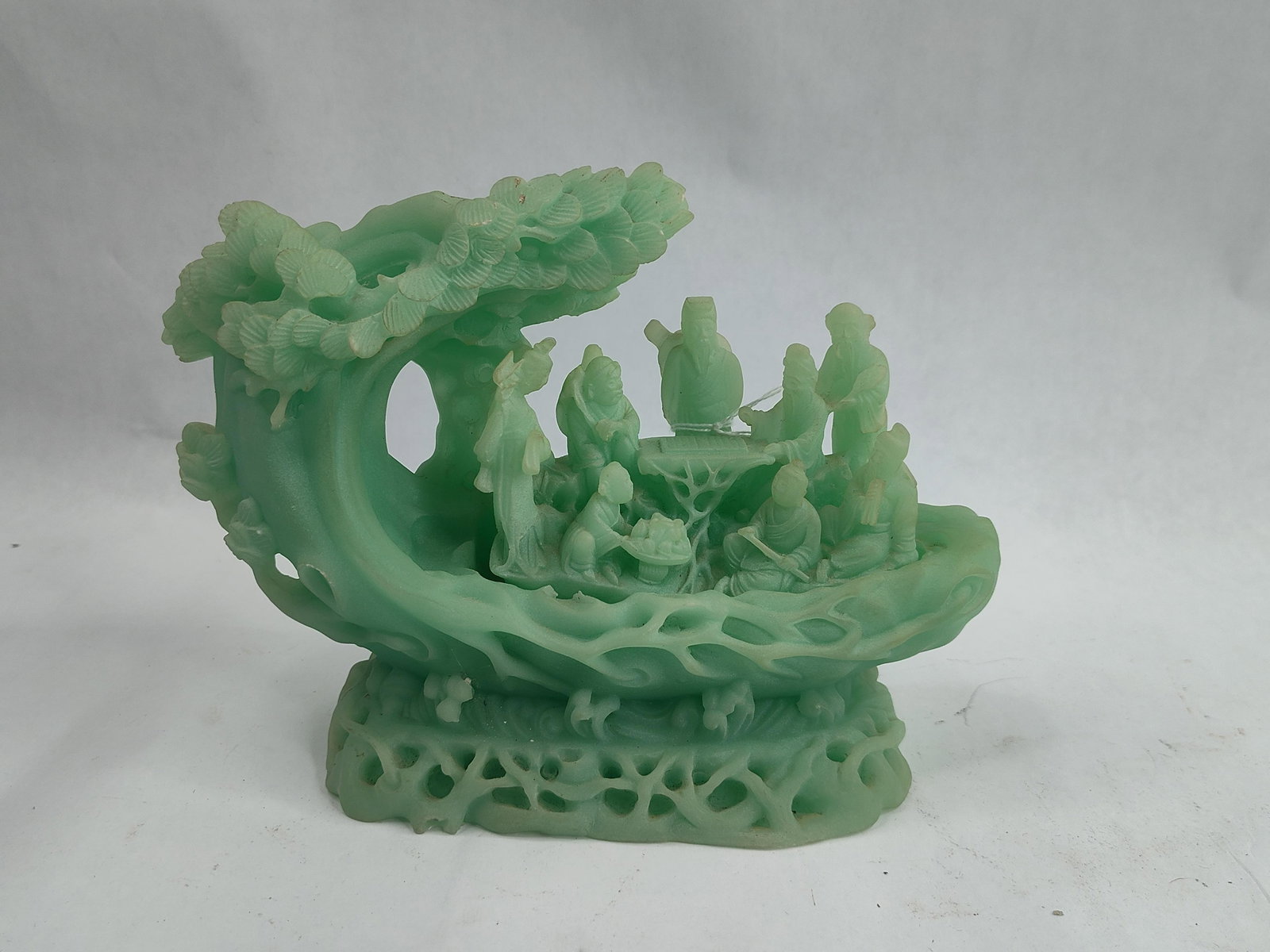 Chinese Fluorite 8 Immortals Sculpture: A Chinese ornamental sculpture carved from a translucent light green stone, consistent in appearance with fluorite. The composition depicts a traditional narrative scene featuring a group of figures,