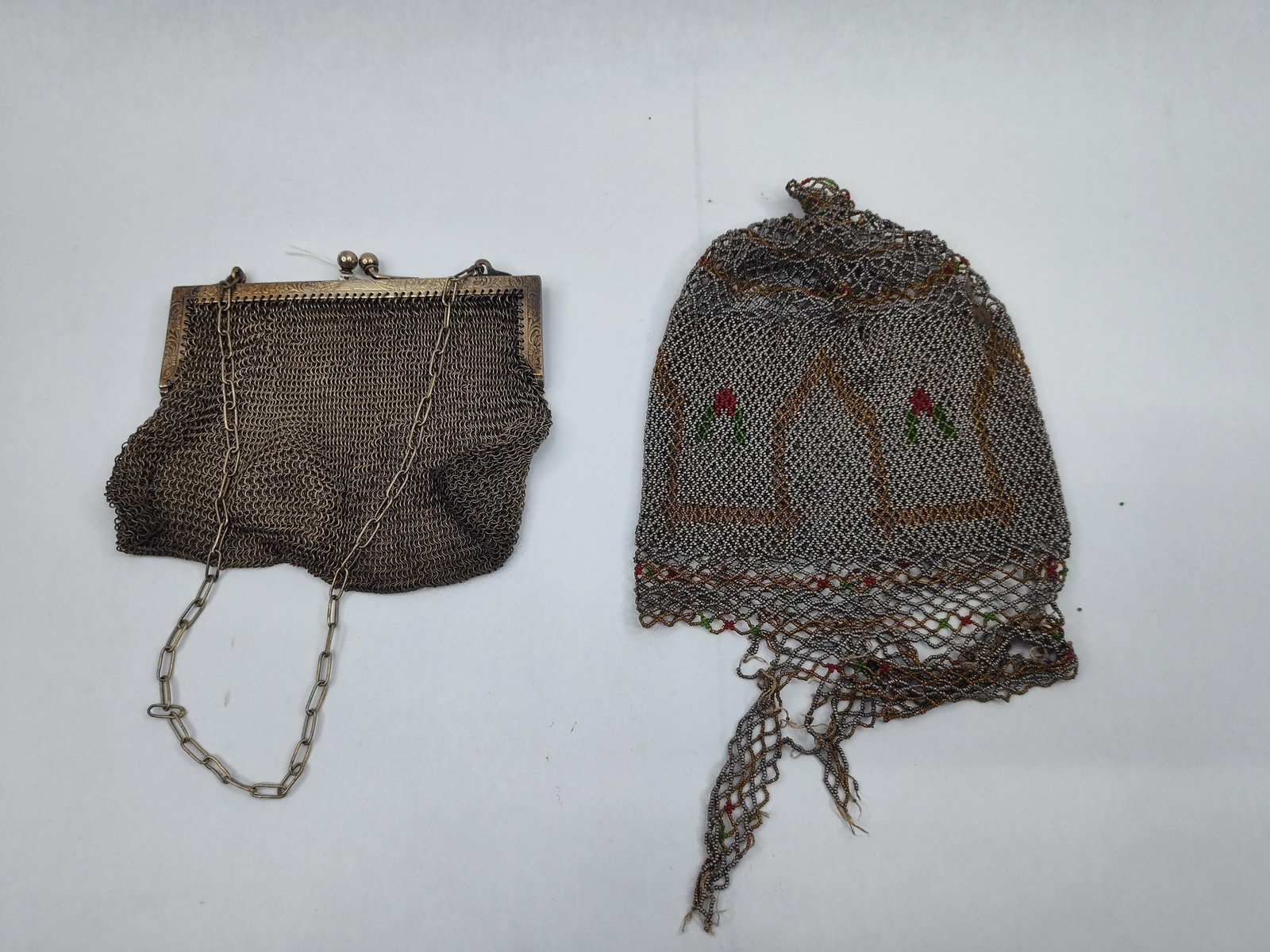 Pair German Silver & Beaded Mesh Purses: This lot comprises two evening bags. The first is a metal mesh purse featuring a rectangular frame with embossed floral and scrollwork decoration. The bag is constructed from fine, interlinked metal r