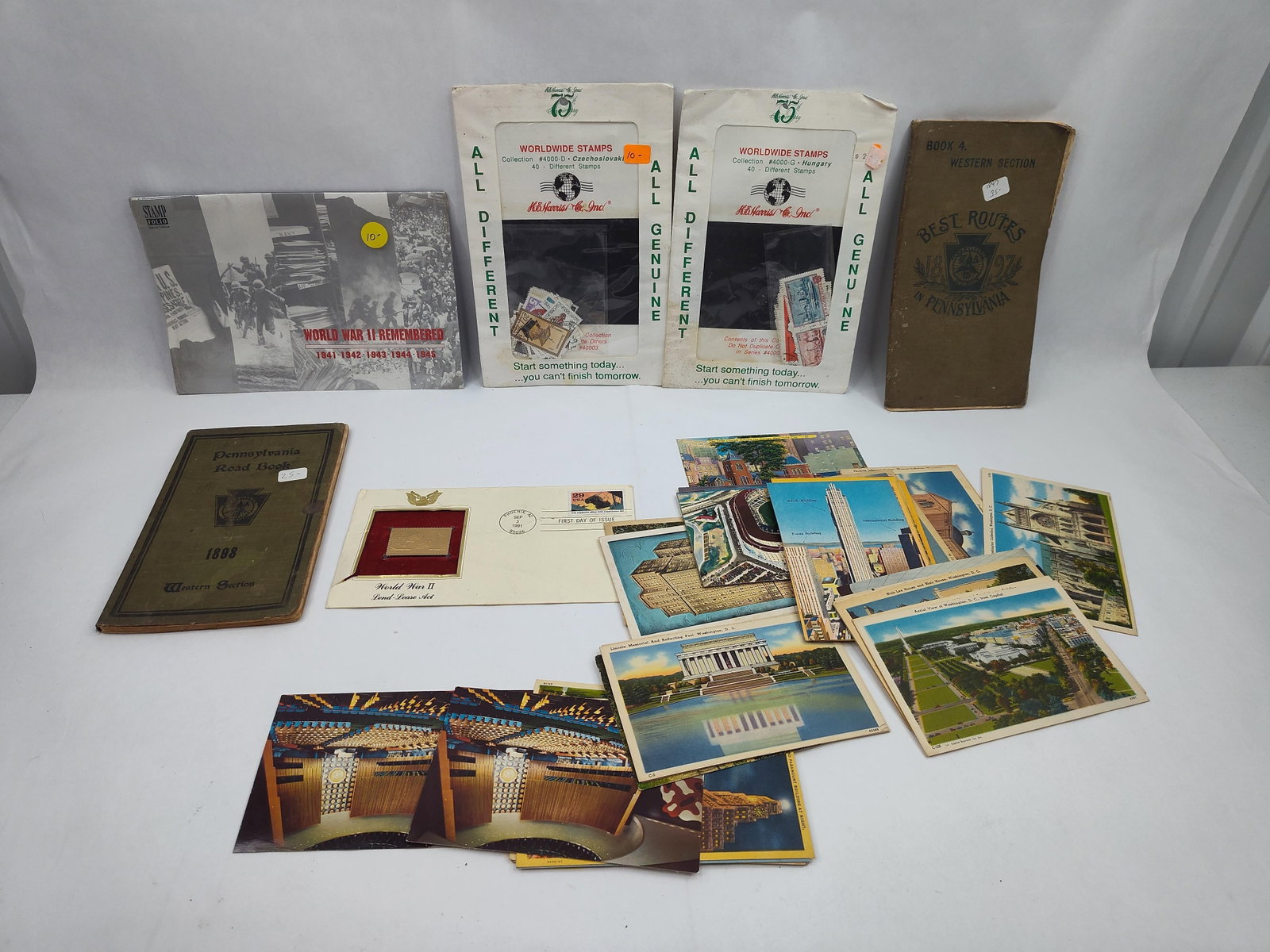 Philatelic, Postcards & PA Books: A collection of ephemera and philatelic items. The lot includes two softcover guides: one titled Book 4. Western Section Best Routes in Pennsylvania 1897 and another titled Pennsylvania Road Book