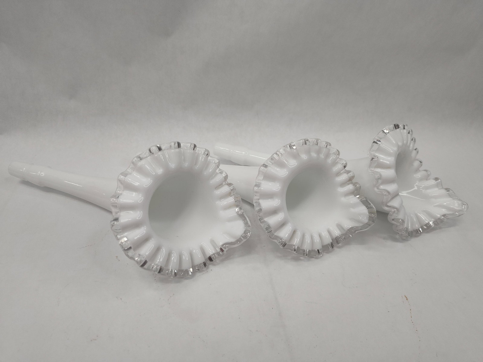 Trio Milk Glass Epergne Horns w/ Str: A trio of trumpet-form epergne inserts, also known as lilies or horns, crafted from opaque white milk glass. Each piece features a long, tapering body that flares into a wide, deeply crimped and