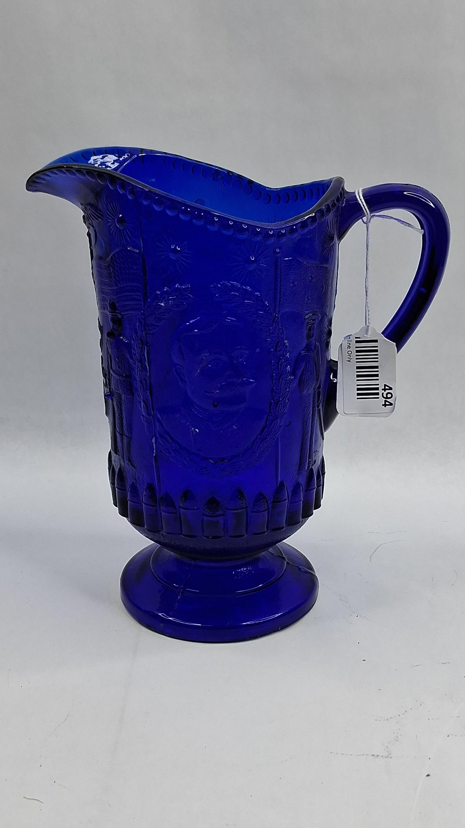 Dewey Commemorative Cobalt Glass: This commemorative pitcher is crafted from heavy cobalt blue pressed glass, designed as a tribute to Admiral George Dewey and the victory at Manila Bay during the Spanish-American War. The vessel