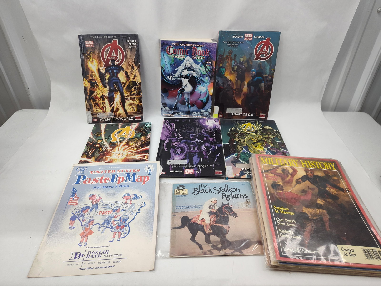 Marvel Graphic Novels, Guides & Mags: An assortment of printed media and ephemera featuring contemporary graphic novels, a 2024-2025 price guide, and magazines. The collection includes several hardcover graphic novels from the Marvel