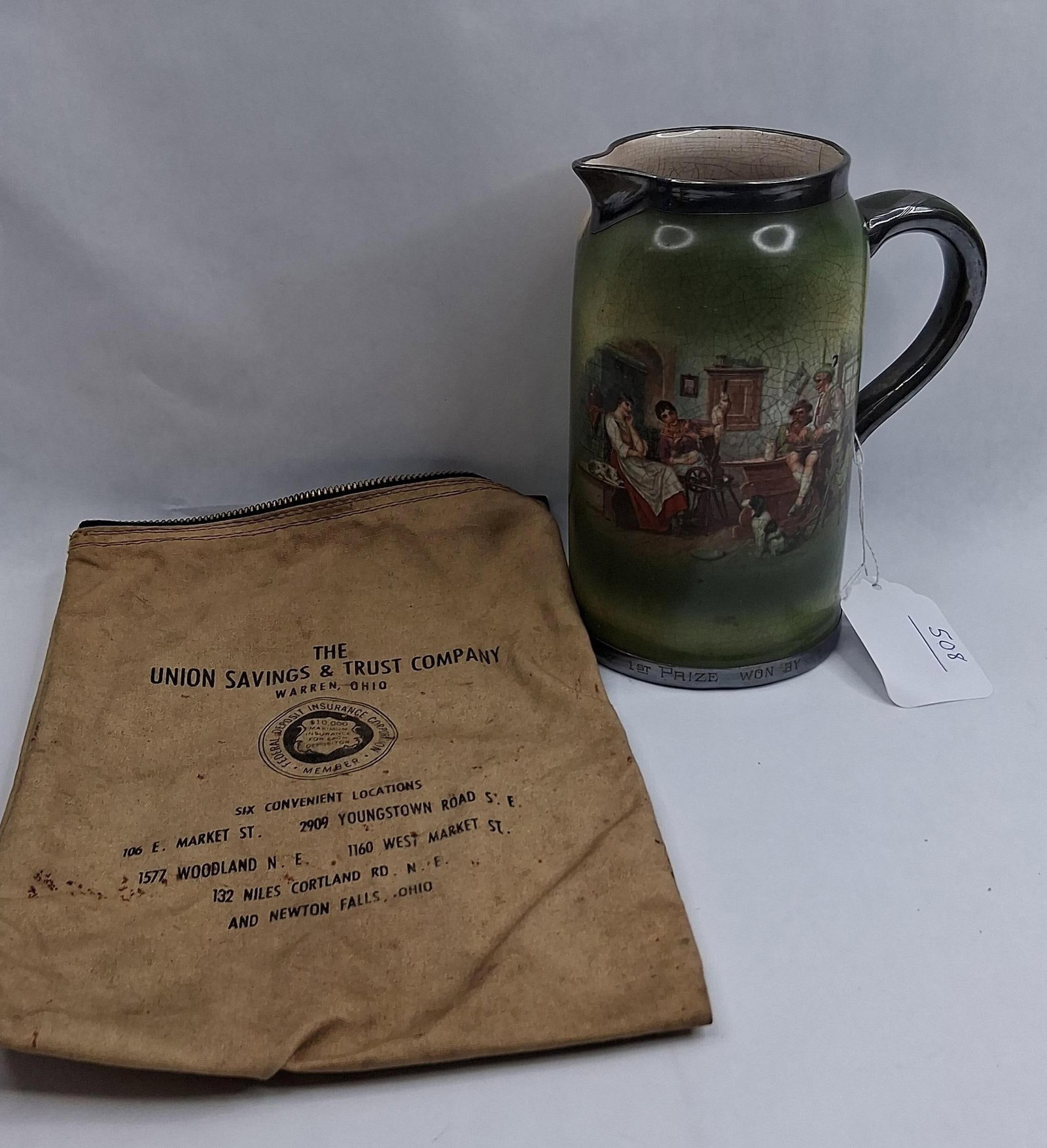 Morris & Willmore Str. Golf Pitcher &: This lot features a ceramic pitcher and a canvas bank bag. The pitcher, produced in Trenton, New Jersey, functions as a 1907 golf trophy. It is constructed from earthenware with a green glaze and a la