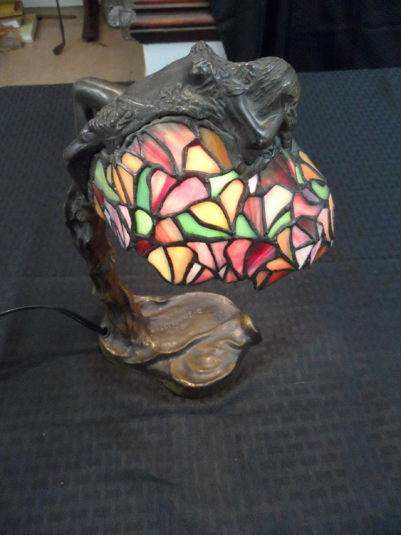 Vintage E. Thomasson Stained Glass Lamp: Vintage E.Thomasson stained glass bronze finished lamp. Lamp is a Art Nouveau Style with a nude woman modeled on top. Measures 8.0 W X4.5 depth X12 .9 height.