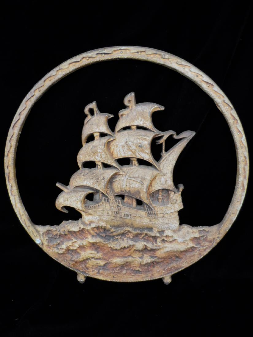 Antique Cast Iron Ship Fireplace Screen: Antique cast iron fireplace screen. Screen is a round shape and depicts a ship on rough seas. Sail designs includes a sun, star, moon. Screen is missing support brackets. Measures 17.5" across