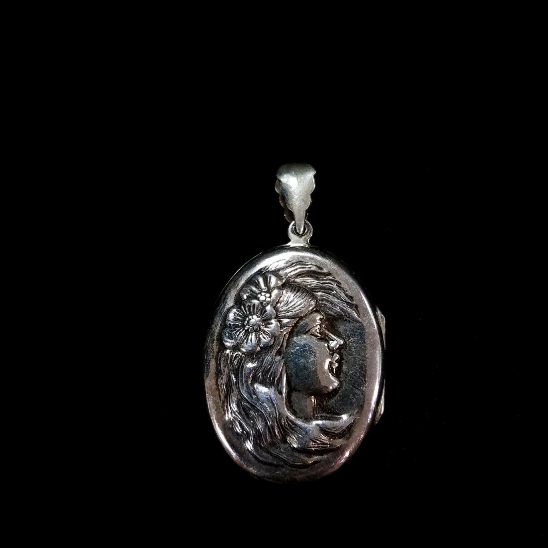 Antique Sterling Art Nouveau Locket: Antique Sterling Art Nouveau Locket. Excellent condition. Depicts a woman with floral hair bouquet. 2.25"x1.25"