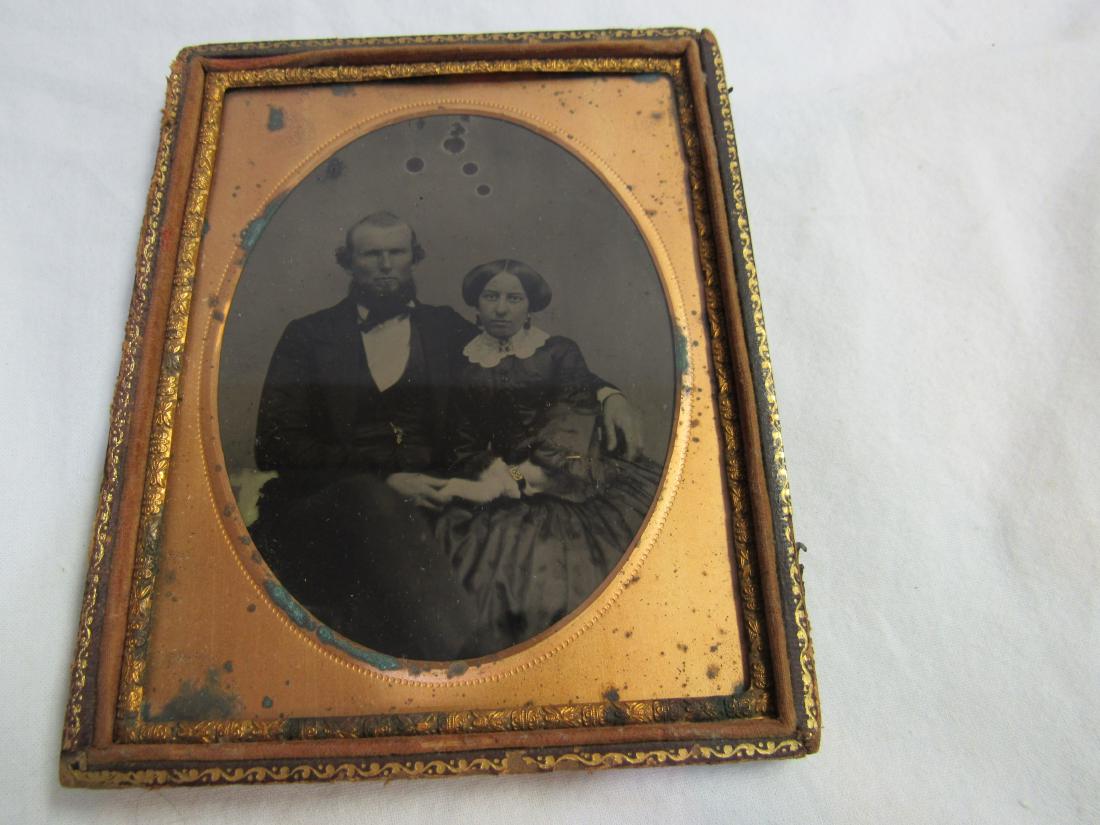 Half Plate Ambrotype of Husband and Wife: Half Plate Ambrotype of Husband and Wife. Wife wearing gold watch, necklace earrings, husband has gold watch chain. Housed in half leather case.