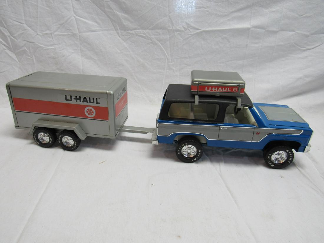 Vintage Ny-Lint Tin SUV with U-Haul Trailer and Roof: Vintage Ny-Lint Tin SUV with U-Haul Trailer and Roof Rack. Truck and trailer in overall very good condition. Truck measures 12.5x5x7.5, trailer 12.5x6x5.25"