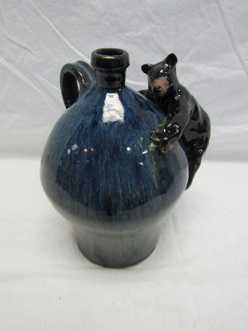 Marvin Bailey Folk Art Bear Jug: Pottery whiskey jug by southern folk artist Marvin Bailey. Jug depicting a southern black bear climbing up the side. Measures 10" tall