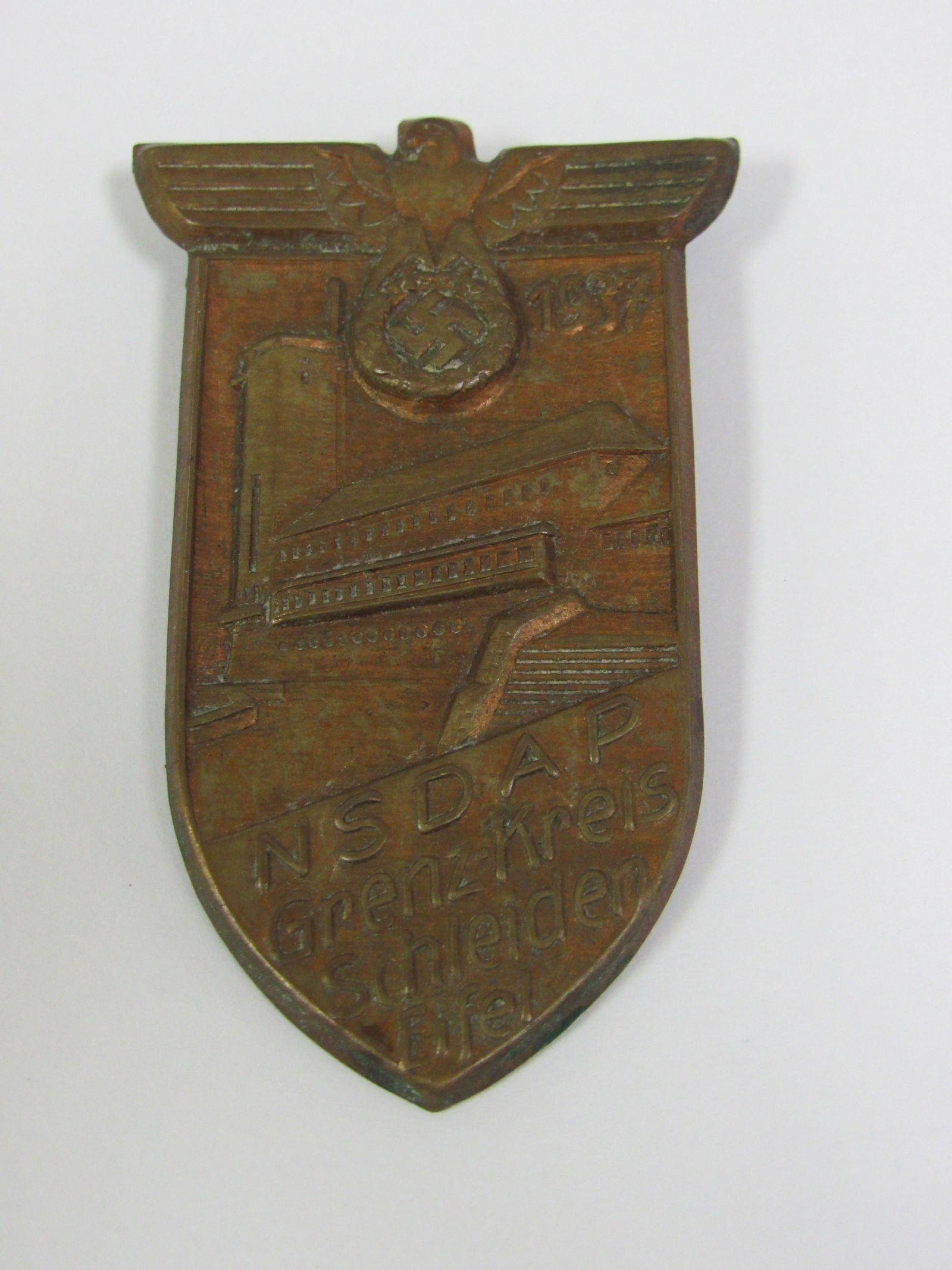 1937 WWII Nazi Germany NSDAP Border District Schleiden: 1937 WWII Nazi Germany NSDAP Border District Schleiden Celebration Badge. Very good condition. 1937 NSDAP Grenz-Kreis Schleiden Eifel badge. Constructed of gilt bronzed metal, horizontal pinback, unma