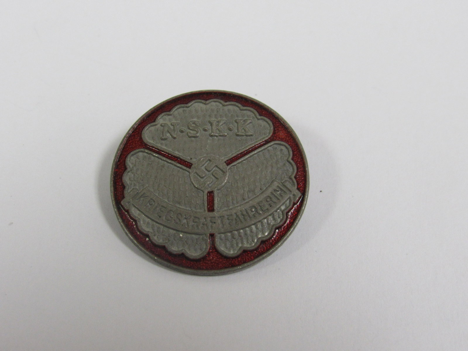 WWII Nazi Germany NSKK III Reich Drivers Badge (for a: WWII Nazi Germany NSKK III Reich Drivers Badge (for a woman driver during wartime). Very good condition. Horizontal pin. Back marked "RZM M1/35". 29mm