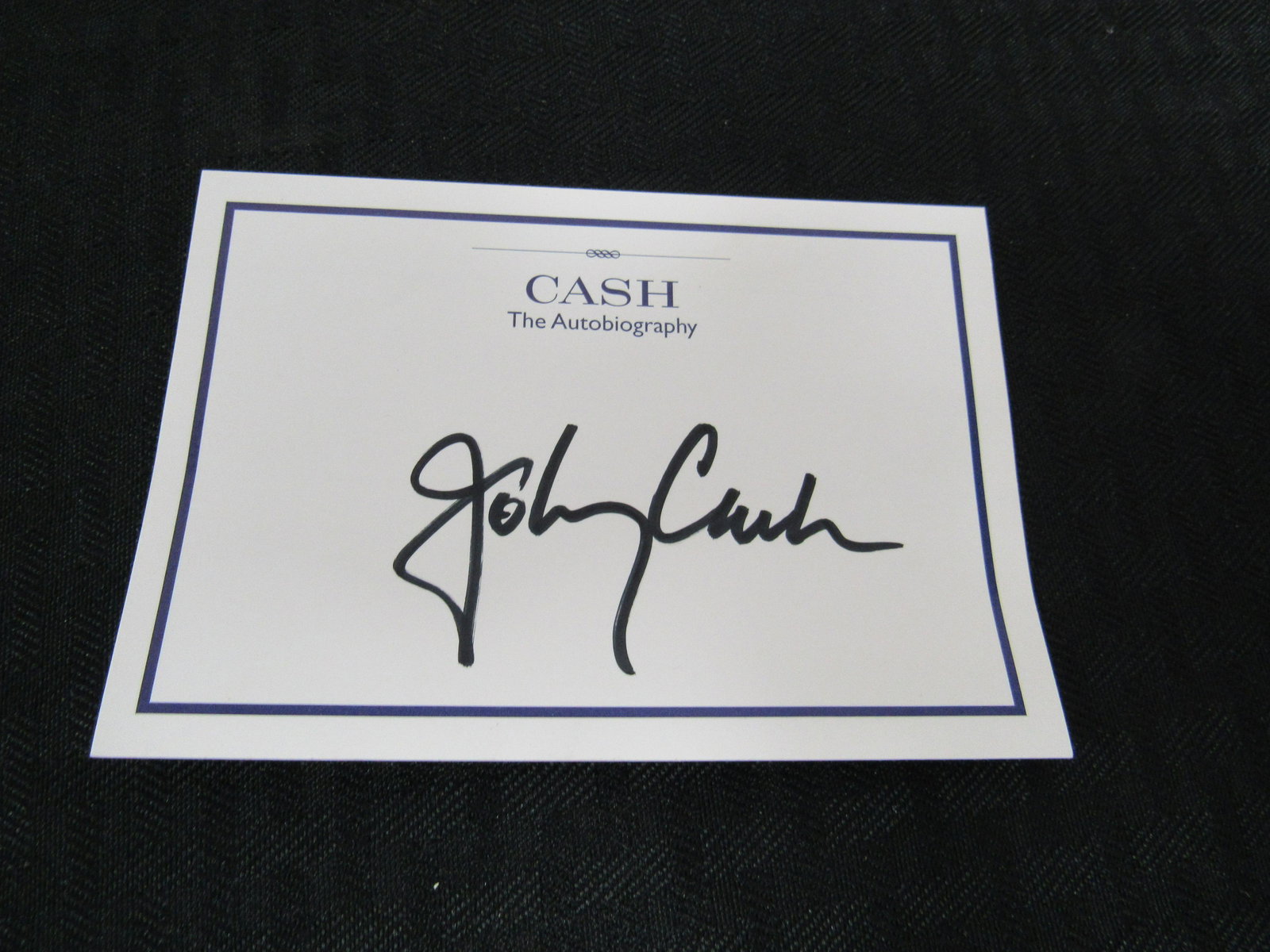 Johnny Cash Signature on Cash Autobiography Sticker: Johnny Cash Signature on Cash Autobiography Sticker. Excellent condition. 5" x 3.5"