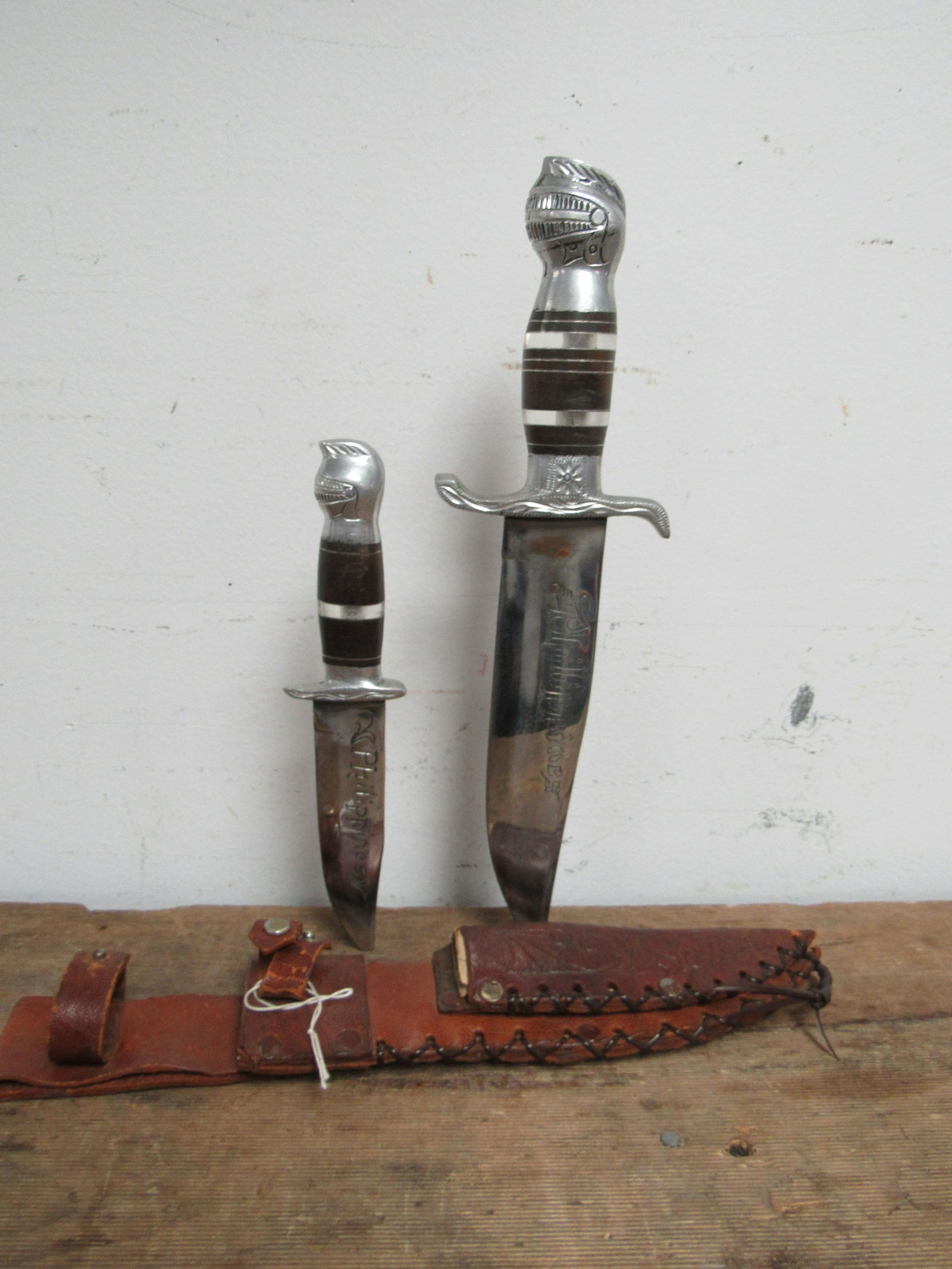 Vintage Philippines 2 Knife Collector Set: Vintage Philippines 2 Knife Collector Set. Both knives come with original leather sheath. Marked Philippines on the blade. The hilt of each knife is decorated with a knight's helmet. Very good conditi