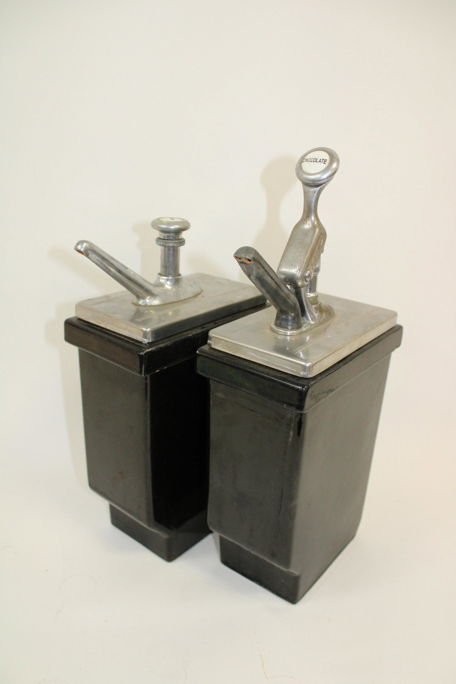 Lot of 2 Hall Porcelain Drugstore Dispensers.: Lot of 2 Hall Porcelain Drugstore Dispensers. Overall good condition with chips, as photographed. Contains 1 lemon dispenser measuring 14" x 7.5" and 1 chocolate dispenser measuring 17" x 7.5".
