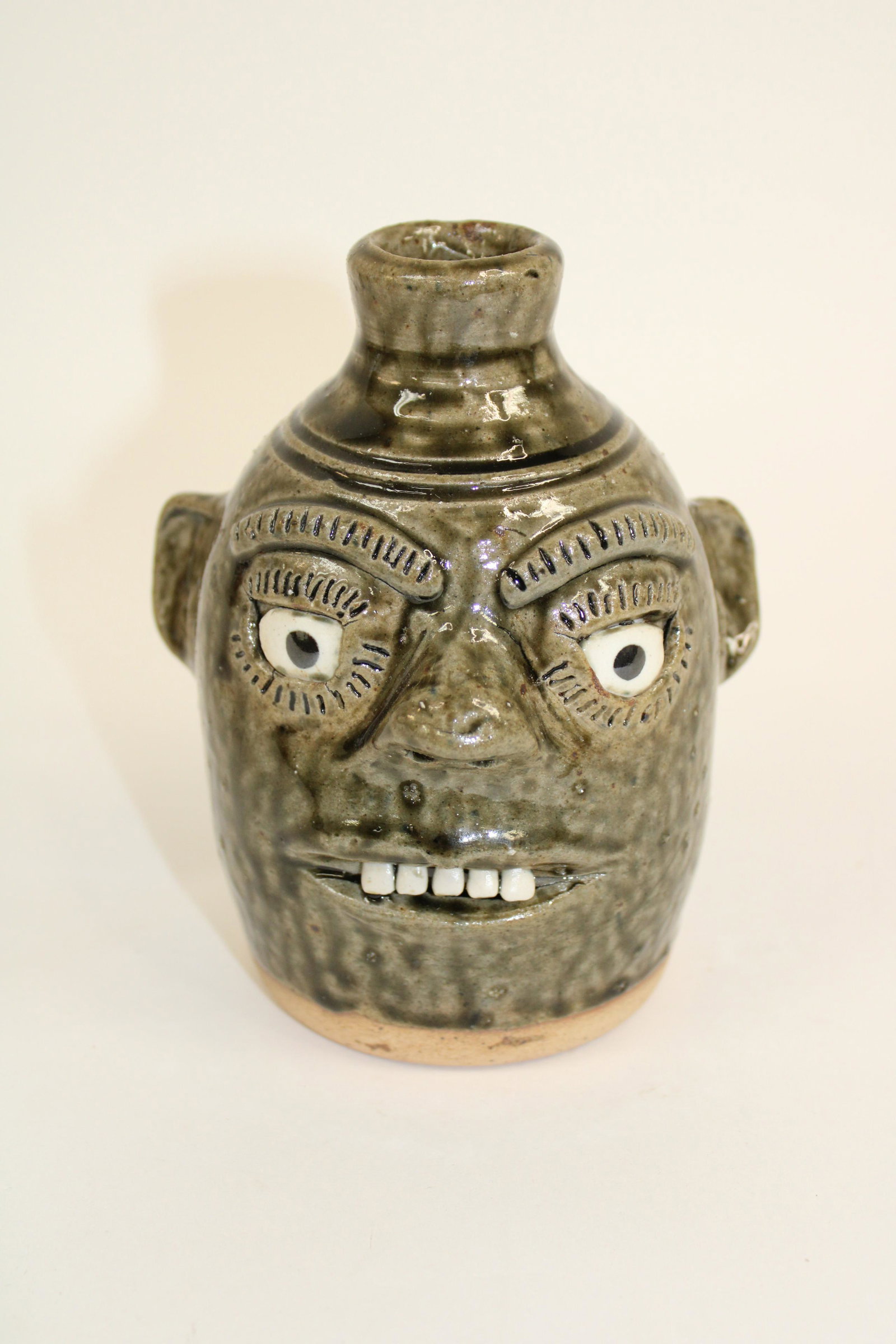 A.G. (Alva Gusta) Meaders (1923-1994) Face Jug.: A.G. (Alva Gusta) Meaders (1923-1994) Face Jug. Jug is signed "A.G. Meaders". Overall excellent condition with no damage and alkaline glaze. Measures 6".