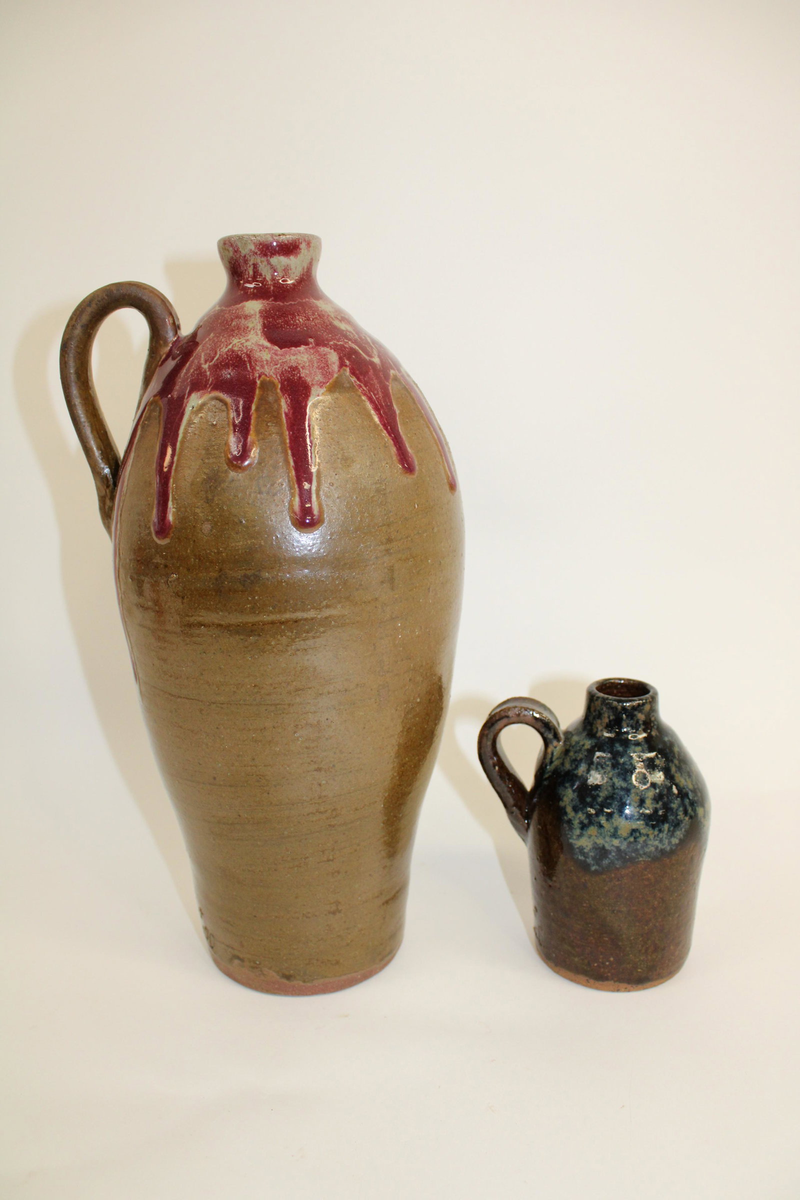 Lot of 2 Kurt Hewell Contemporary Ga Folk Art Jugs.: Lot of 2 Kurt Hewell Contemporary Ga Folk Art Jugs. Both signed and in overall excellent condition. 1 measures 12.5", the other measures 5.5".