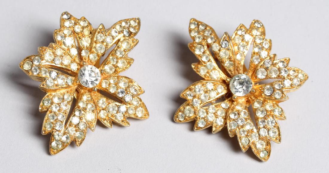 Pair of Kenneth Lane Clip On Earrings: Of flower form with clear rhinestones, stamped on reverse, "Kenneth Lane." 2.75" L.