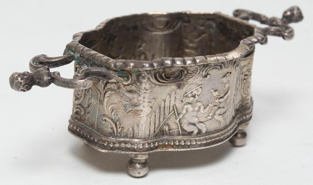 Hanau Sterling Silver Diminutive Salt Cellar: Elaborate repousse, the underside with Karl Kurz Hanau marks and English import sterling hallmarks: London, 1903, maker's mark "TH." 1" H X 3.5" W X 1.5" D. Approx. 1.2 ozt. Some rubbing to details.