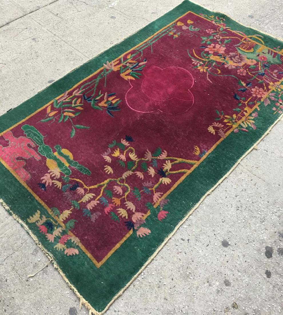 Art Deco Nichols Rug: 4'1" X 6'10.5": The plum color center having decoration of various trees and plants extending over a dark green border. Center with uneven pile; white knots throughout; minor staining.