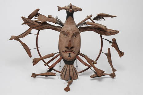 Yup'ik Inuit Shaman Mask, Pacific Northwest: American Indian or Native American, hand-carved and painted, depicting a seabird with man's face on its body surrounded by spirit creatures, such as fish and seal, attached by bird feathers and quills