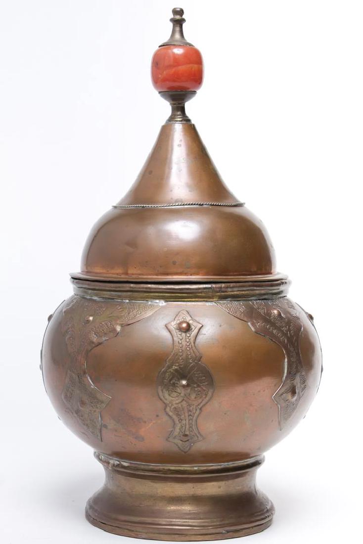 Middle Eastern Copper & Tin Tagine: Moroccan or Turkish, copper with applied, incised and hammered cut card designs, the pointed lid with large carnelian glass bead handle, the interior tin-lined. 13.5" H.