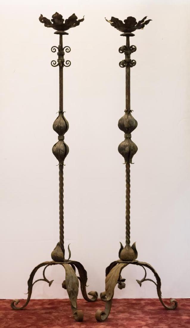 Gothic Revival Wrought Iron Torchieres: Gothic Revival wrought iron standing torchieres, twisted stem with applied scroll elements on tripod base. 63" H.