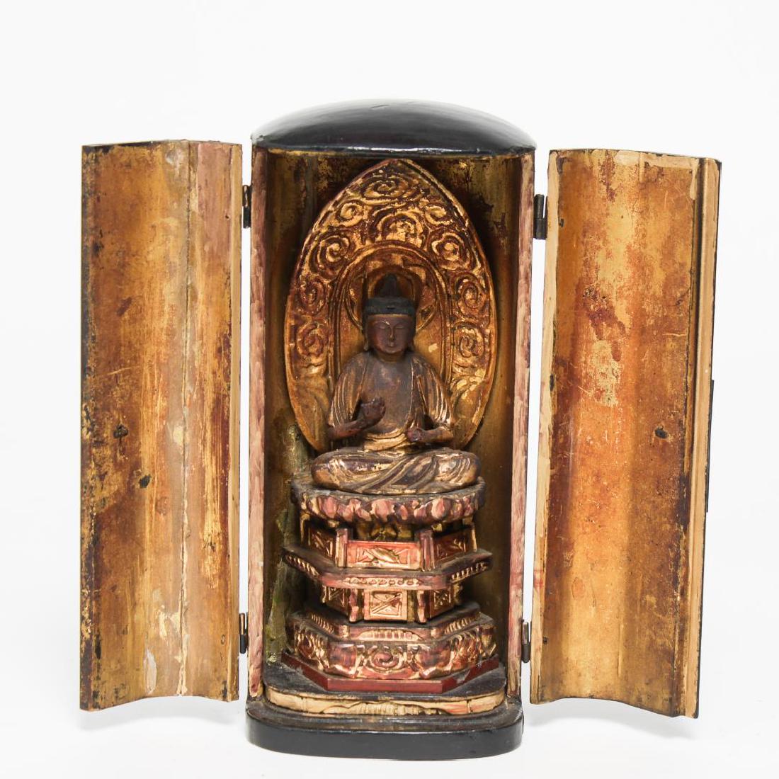 Japanese Zushi Traveling Amida Buddhist Shrine: Japanese zushi traveling shrine, antique, the black lacquer case opening to reveal a gilded interior and seated Amida Pure-Land Buddha atop a tiered lotus throne, in Abhaya mudra, in front of a flame 