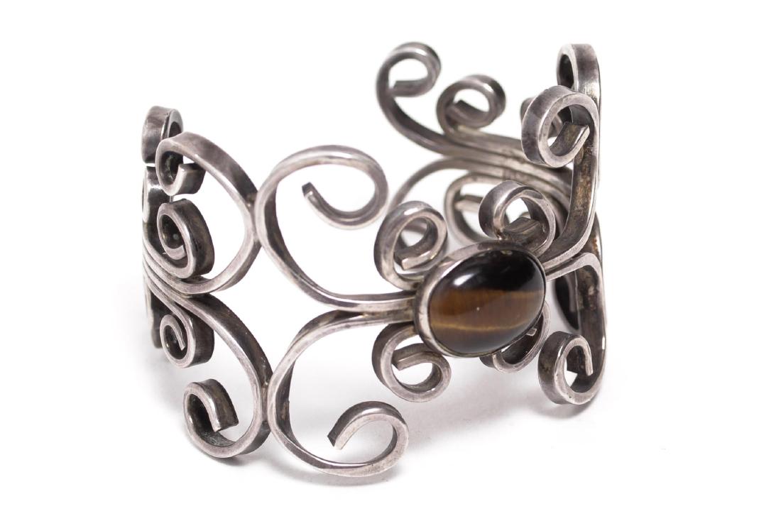 Vintage Silver & Tiger Eye Cuff Bracelet: Vintage tiger eye cuff bracelet, scrolling wrought silver wires around central cabochon; partial maker's mark underneath. 2.2" diameter and adjustable. Approx. total weight 1.9 ozt. Silver tested.