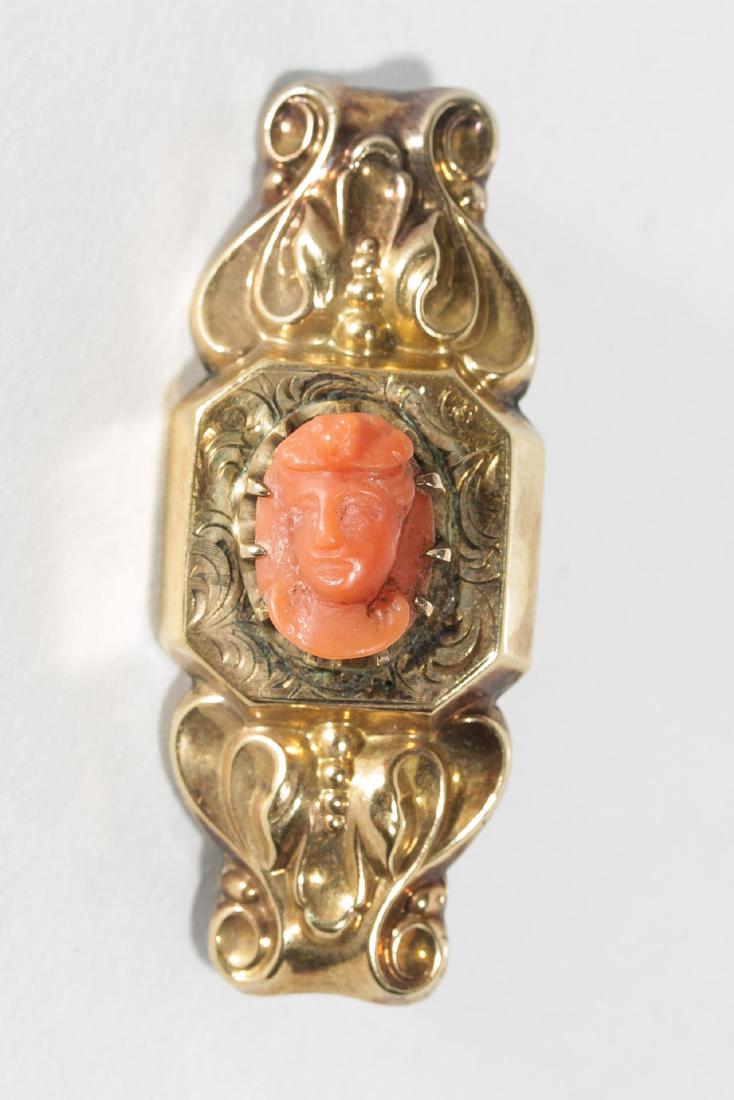 Antique Coral Cameo & 10K Gold Brooch: Antique cameo brooch, a carved coral bust of a lady set into 10K gold, likely Edwardian- or Victorian-Era. 1.25" L. Approx. 2.7 DWT total (including coral).