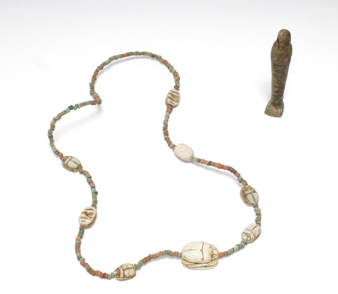 Ancient Egyptian Faience Ushabti & Scarab Necklace: Ancient Egyptian antique pieces, comprising an archaeological small green faience ushabti figure painted possibly later with hieroglyphics, the second a scarab necklace, the clay insects carved with h